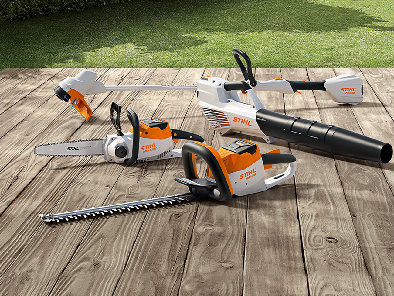 Акумуляторна ланцюгова пила STIHL MSA 120 C, акумуляторний тример для газону FSA 57, акумуляторні мотоножиці HSA 56, акумуляторна повітродувка BGA 56 на дерев’яному настилі