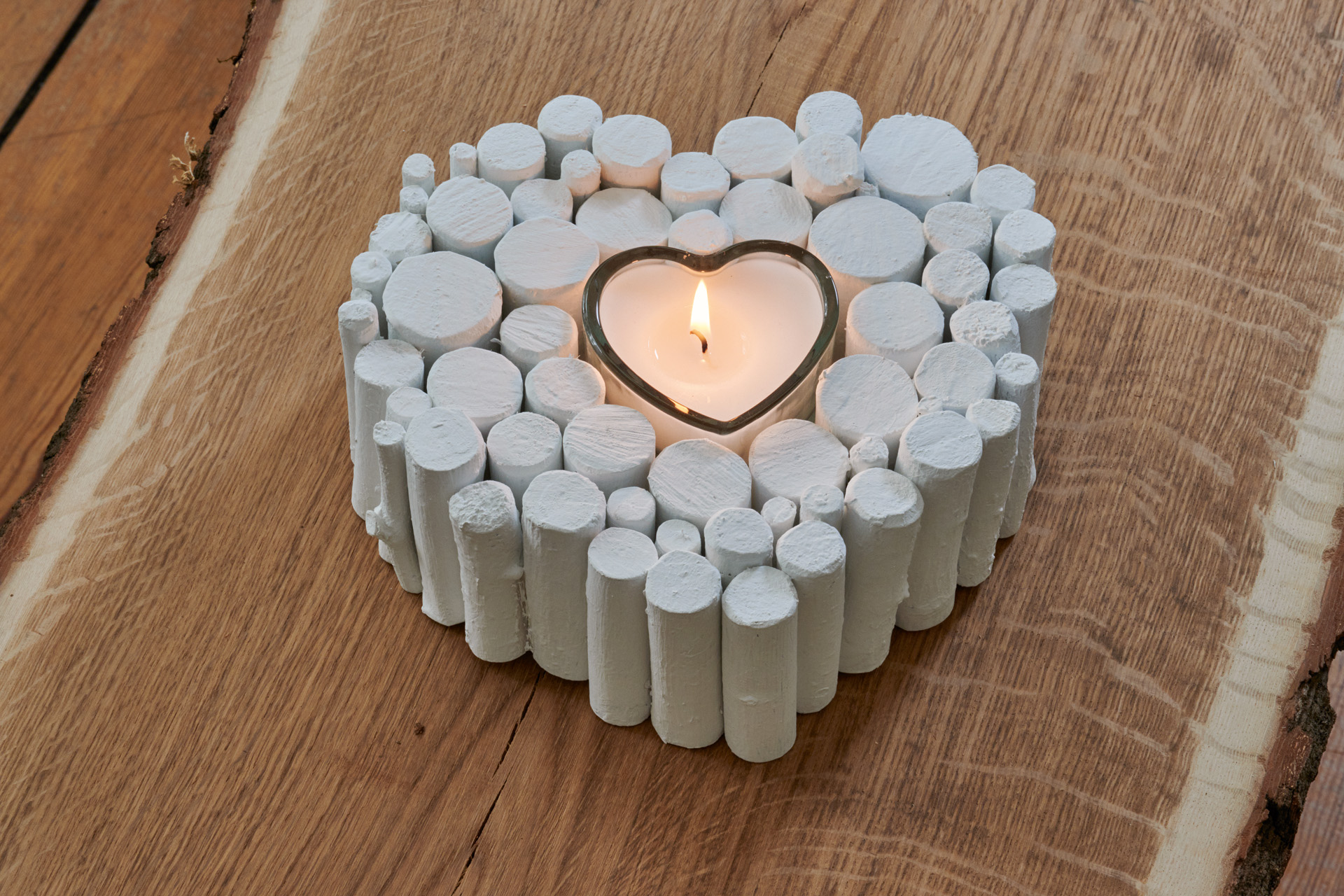 Weißes Herz aus Ästen mit brennender Kerze als Geschenk zum Valentins- oder Muttertag