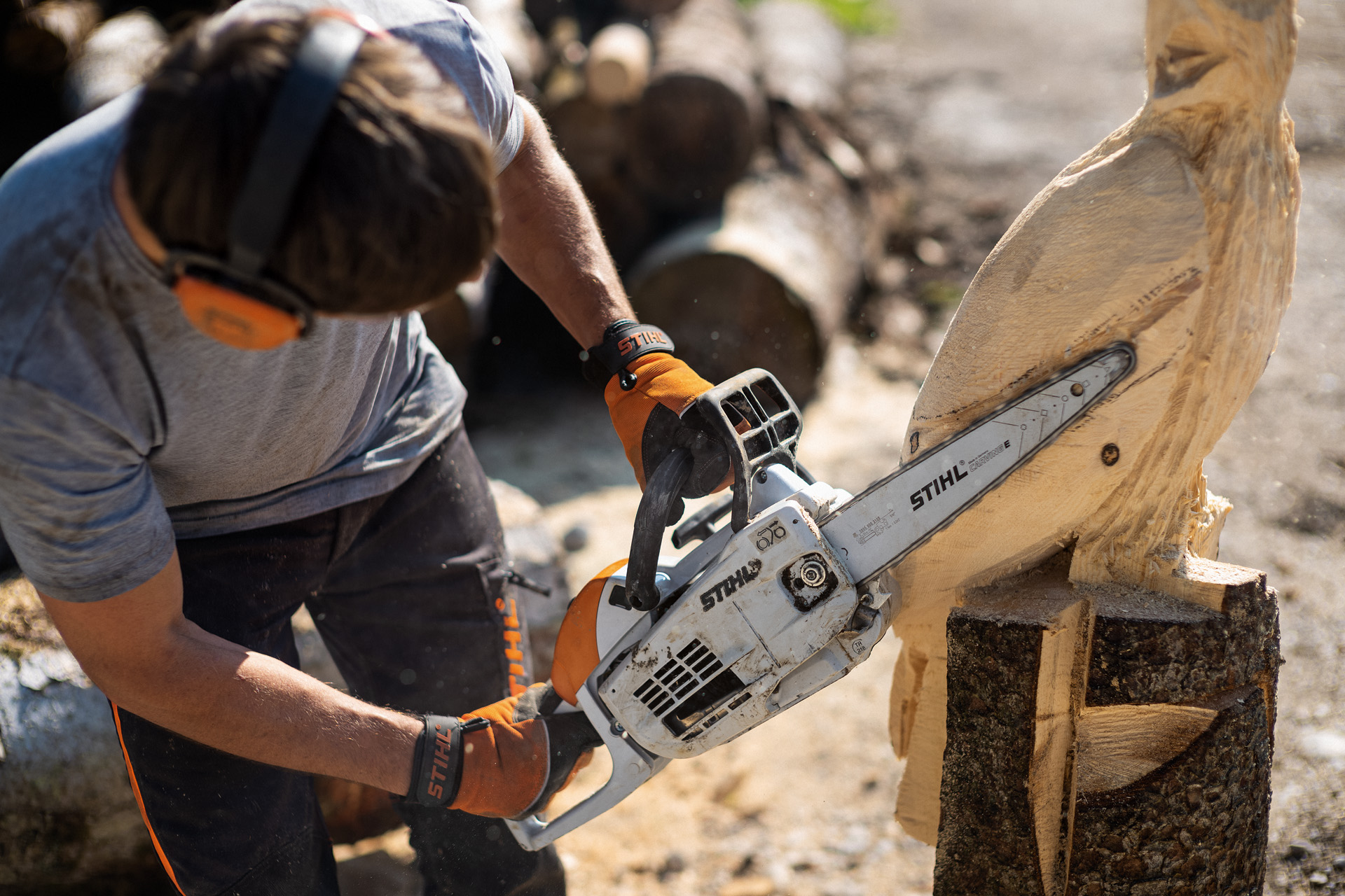 Mann schnitzt Eule mit STIHL Kettensäge