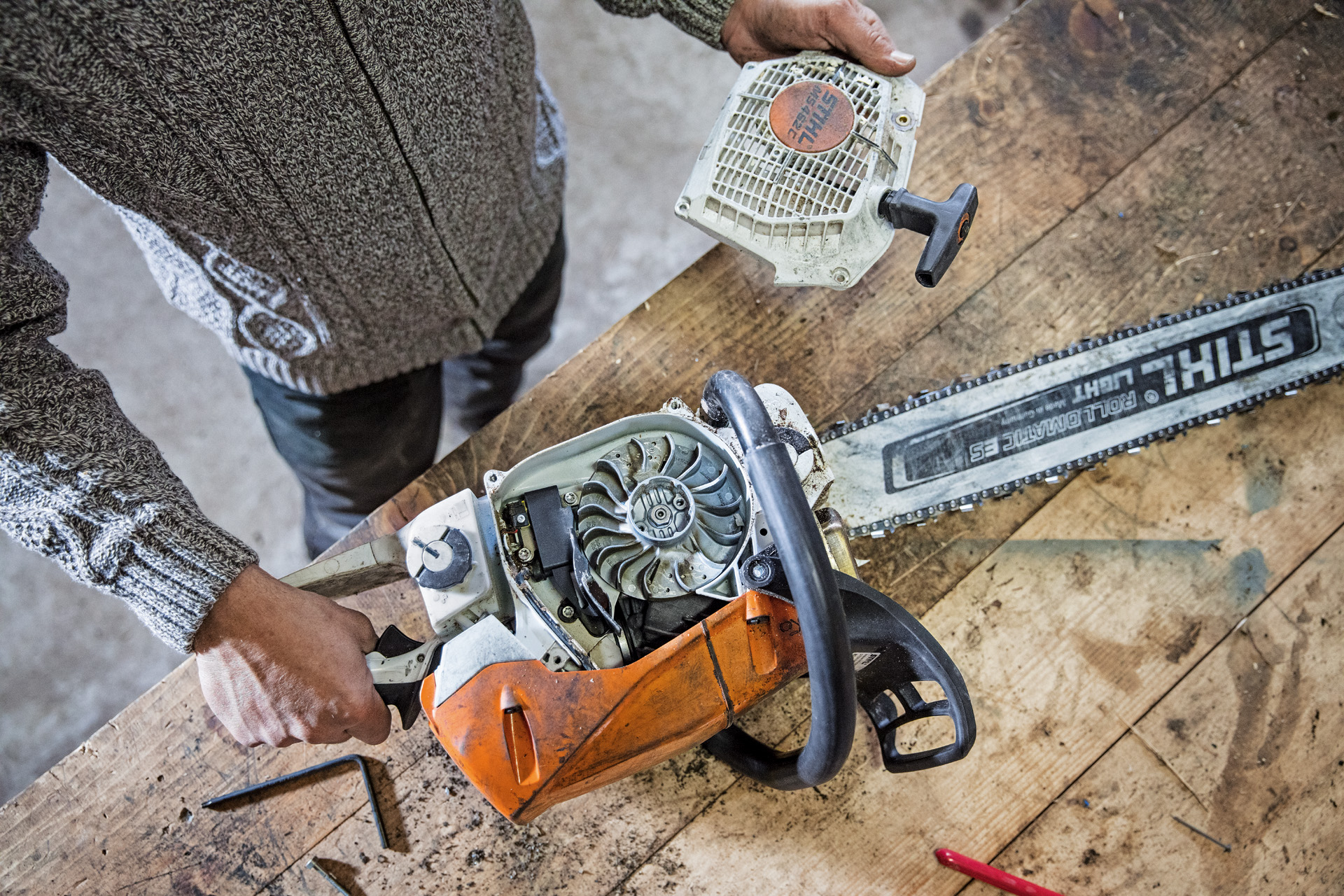 Людина, яка обслуговує бензопилку STIHL MS 462 C-M на робочому столі